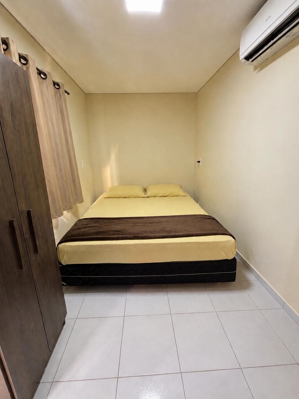 Quarto duplo com cama de casal, guarda-roupa e ar-condicionado